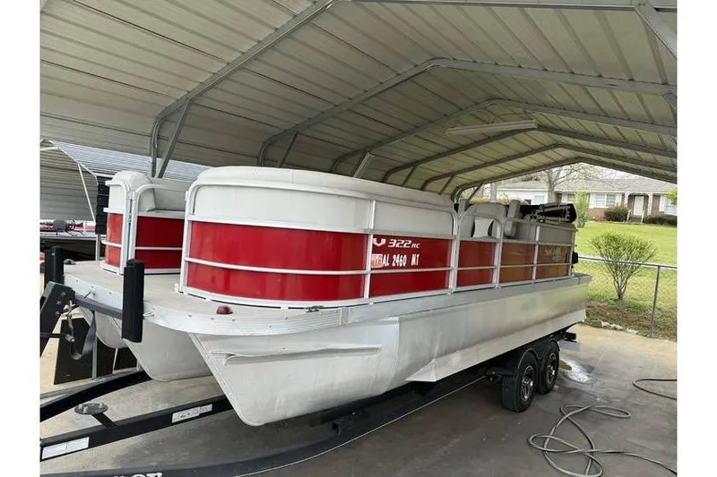 The Image of 2016 G3 Angler V145 boat under metal shelter, red and white design. - 0