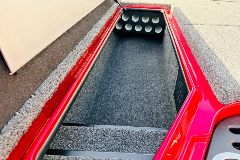 Slide: The Image of Interior storage compartment of 2020 Nitro Z21 Pro boat, featuring carpeted lining and rod holders. - 23