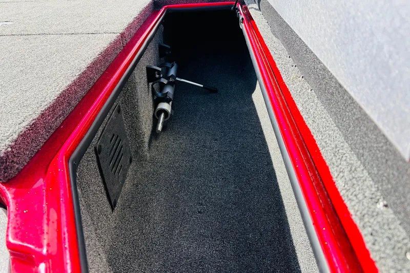 Slide: The Image of Storage compartment of a 2020 Nitro Z21 Pro boat, featuring red trim and carpeted interior. - 26