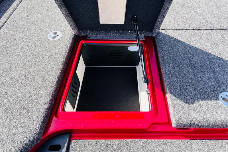 Slide: The Image of 2020 Nitro Z21 Pro boat storage compartment with red trim and carpeted interior. - 28