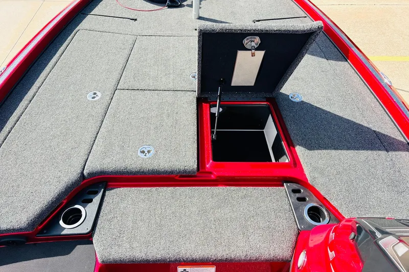 Slide: The Image of 2020 Nitro Z21 Pro boat deck with open storage compartment, gray carpeting, and red trim. - 29