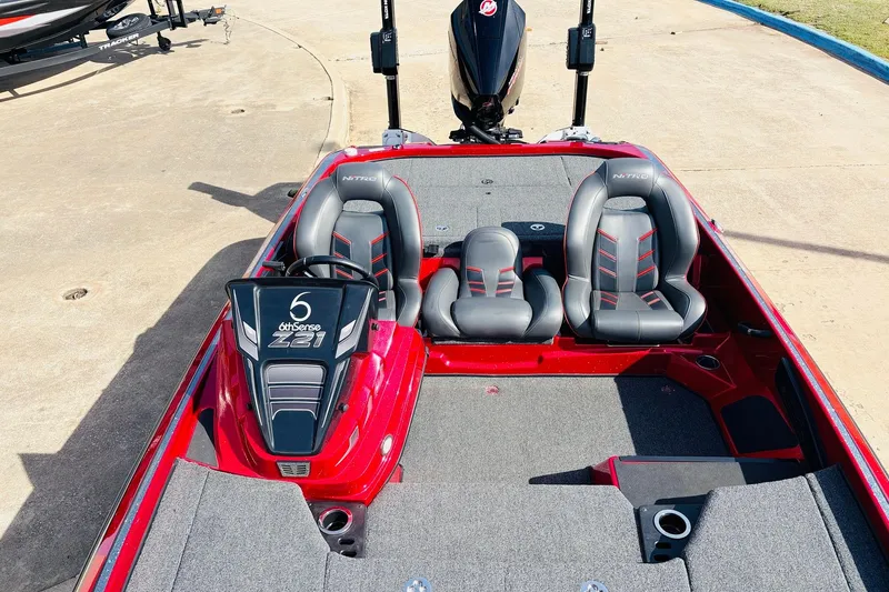 Slide: The Image of 2020 Nitro Z21 Pro boat with red and gray seating, parked on concrete. - 35