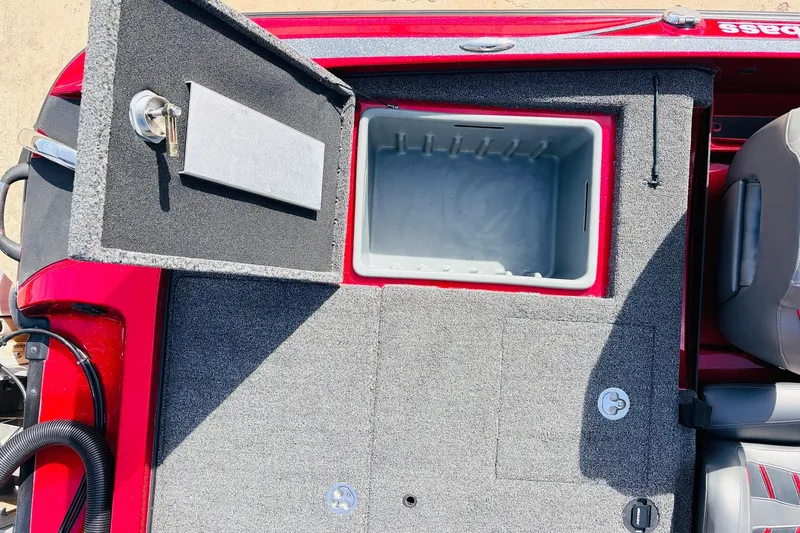 Slide: The Image of Open storage compartment on a 2020 Nitro Z21 Pro boat, featuring a red and gray interior. - 54