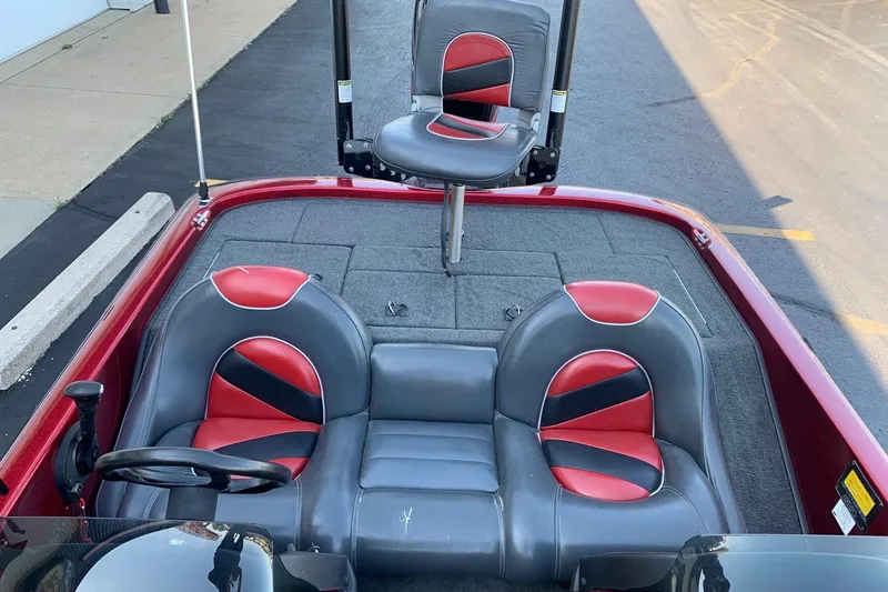 Slide: The Image of 2001 Ranger R83 boat interior with red and gray seating, steering wheel, and carpeted deck. - 6