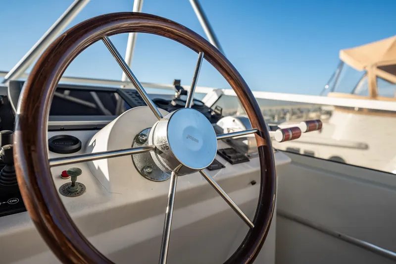 Slide: The Image of Steering wheel of 2004 Navigator 5700 Rival Pilothouse yacht under clear blue sky. - 11
