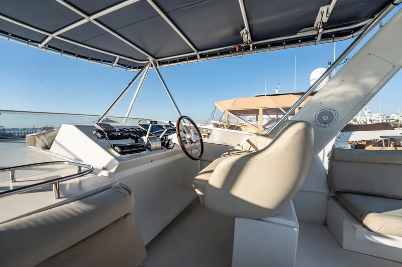 Slide: The Image of Luxurious 2004 Navigator 5700 Rival Pilothouse yacht helm with leather seating and canopy. - 12