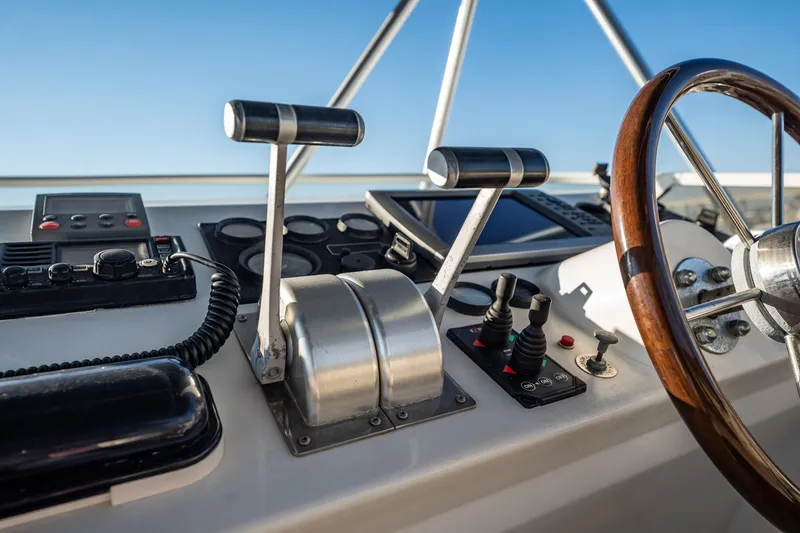 Slide: The Image of Pilothouse controls of 2004 Navigator 5700 Rival, featuring steering wheel and throttle levers. - 13