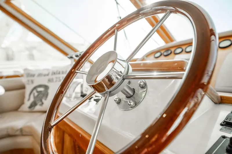 Slide: The Image of Steering wheel of 2004 Navigator 5700 Rival Pilothouse yacht, showcasing elegant wood and chrome design. - 26