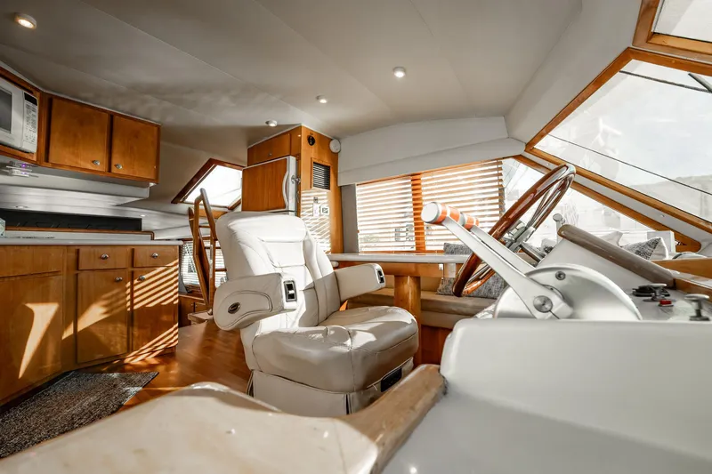 Slide: The Image of Luxurious 2004 Navigator 5700 Rival Pilothouse interior with modern helm and wooden cabinetry. - 28
