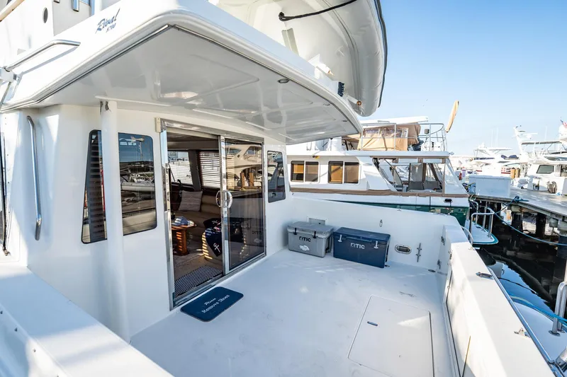 Slide: The Image of 2004 Navigator 5700 Rival Pilothouse yacht docked, featuring spacious deck and sliding glass doors. - 5