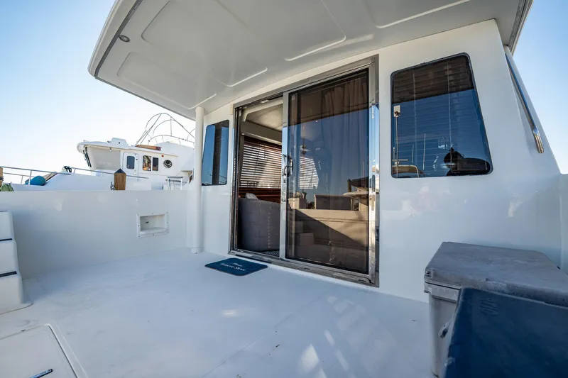 Slide: The Image of 2004 Navigator 5700 Rival Pilothouse yacht deck with sliding glass door and seating area. - 8