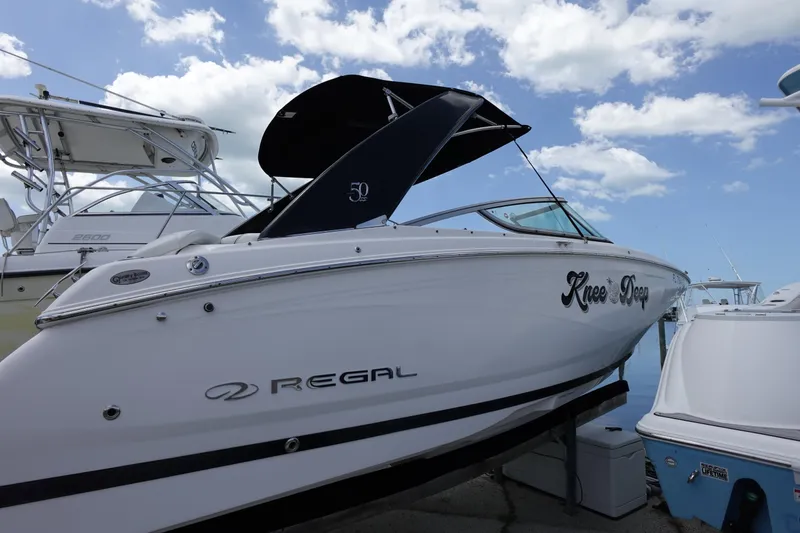Slide: The Image of 2021 Regal 23 OBX boat docked under a blue sky with clouds. - 13