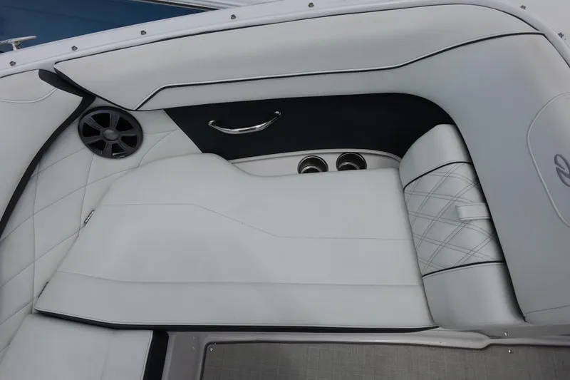 Slide: The Image of Luxurious white seating area on a 2021 Regal 23 OBX boat, featuring cup holders and speaker. - 19