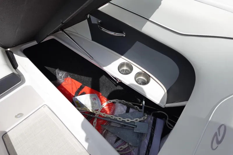Slide: The Image of Storage compartment in a 2021 Regal 23 OBX boat with safety equipment and anchor. - 20
