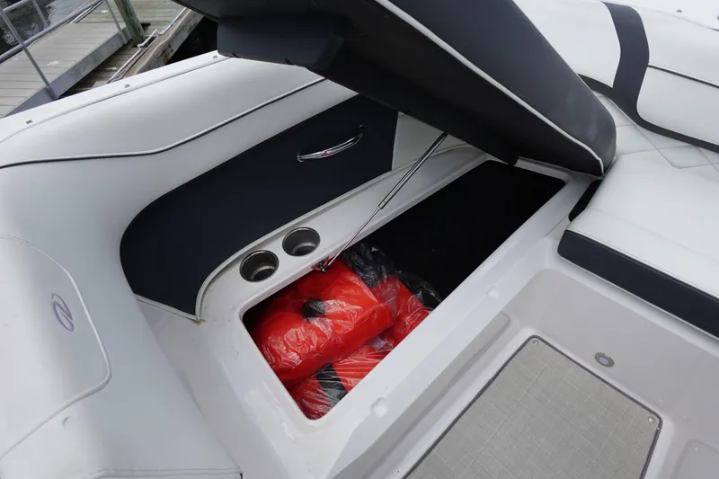 Slide: The Image of 2021 Regal 23 OBX boat storage compartment with life jackets and cup holders. - 22