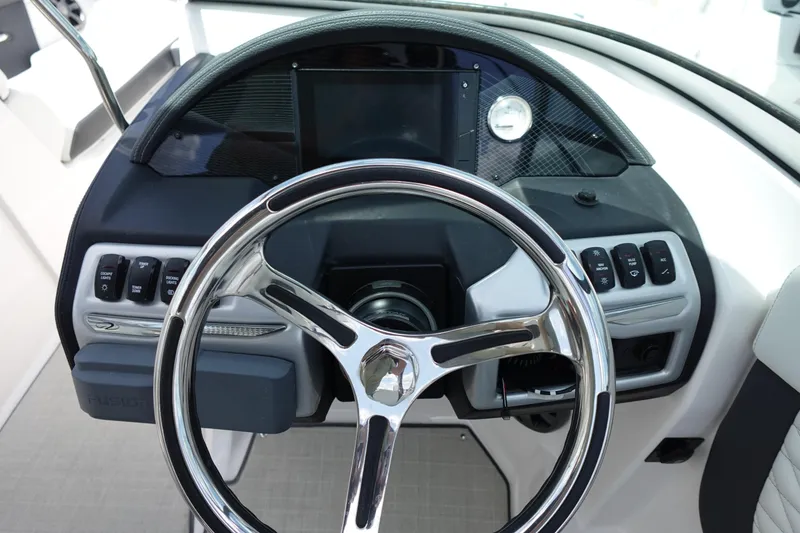 Slide: The Image of Steering wheel and dashboard of 2021 Regal 23 OBX boat, featuring modern controls and design. - 24