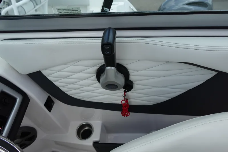 Slide: The Image of Interior of 2021 Regal 23 OBX boat with white quilted upholstery and control lever. - 25