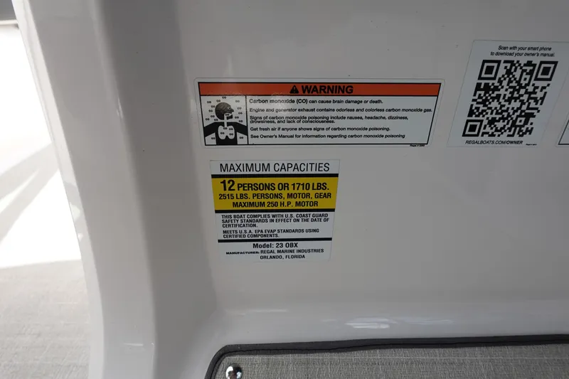 Slide: The Image of Warning and capacity labels on 2021 Regal 23 OBX boat, including QR code. - 30