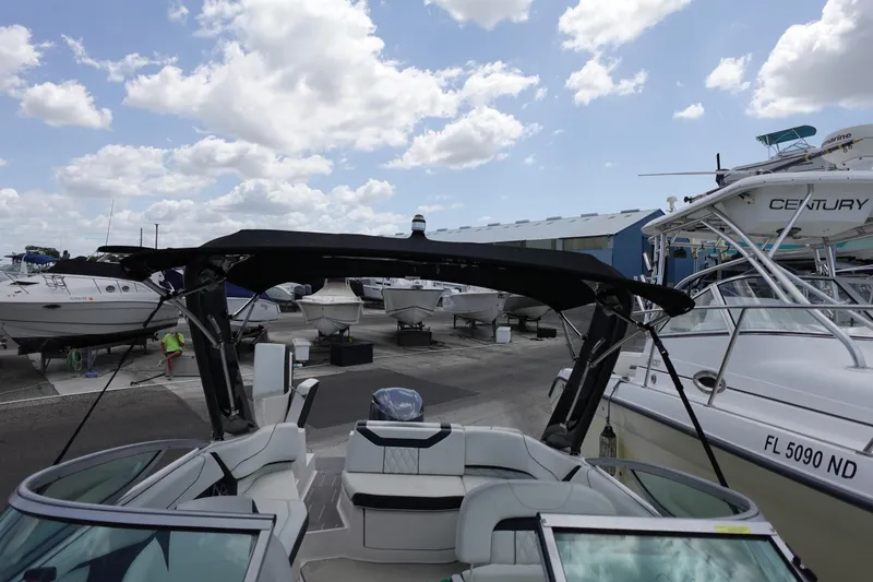Slide: The Image of 2021 Regal 23 OBX boat docked among other vessels under a partly cloudy sky. - 31