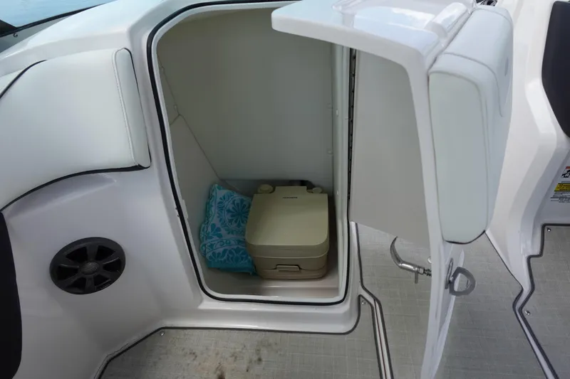 Slide: The Image of 2021 Regal 23 OBX boat interior with open storage compartment and portable toilet. - 34