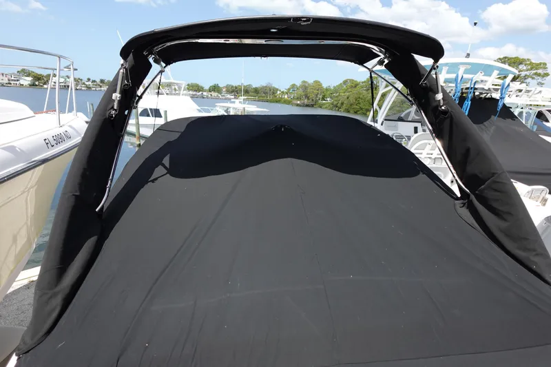 Slide: The Image of 2021 Regal 23 OBX boat with black cover docked at marina. - 4