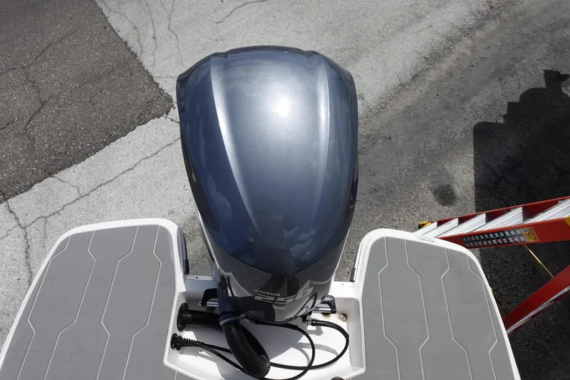 Slide: The Image of Top view of a 2021 Regal 23 OBX boat's outboard motor on a textured surface. - 52