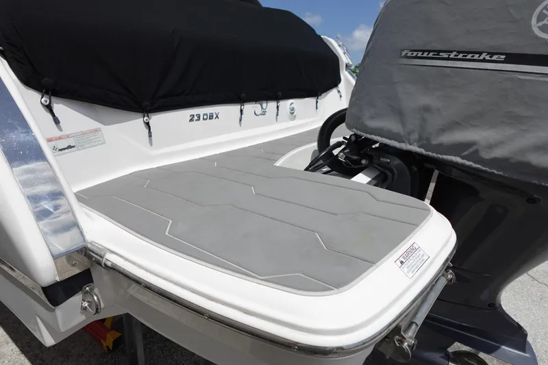 Slide: The Image of 2021 Regal 23 OBX boat with covered outboard motor and swim platform. - 56