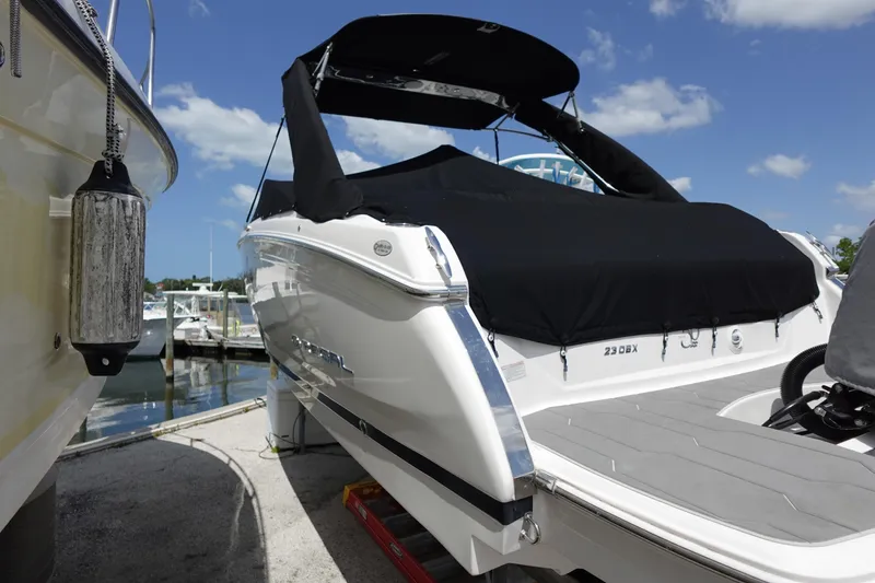 Slide: The Image of 2021 Regal 23 OBX boat docked with black cover under blue sky. - 60