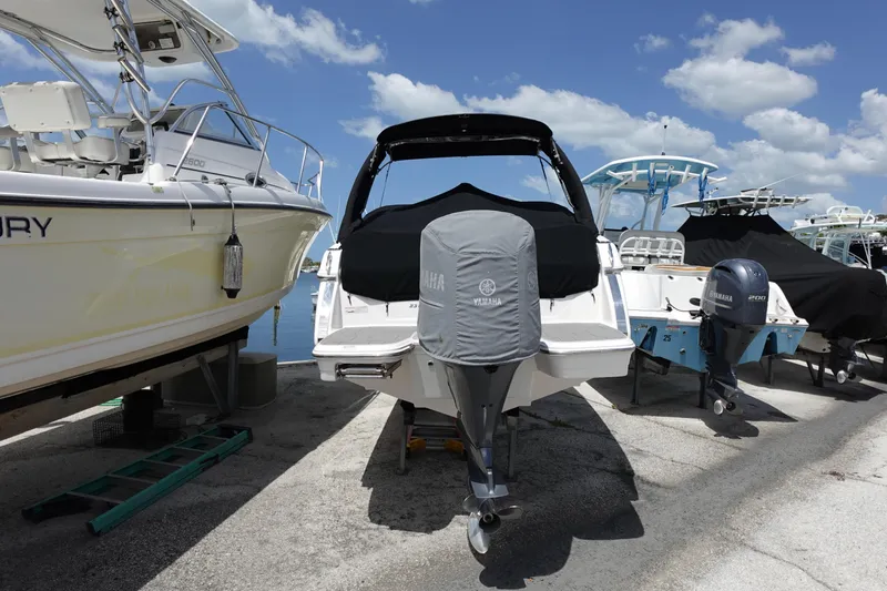 Slide: The Image of 2021 Regal 23 OBX boat with Yamaha outboard motor, docked under a clear sky. - 66