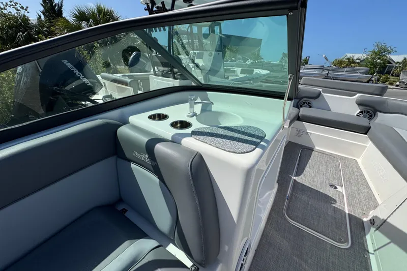 Slide: The Image of 2023 NauticStar 243 DC boat interior with seating and cup holders. - 12