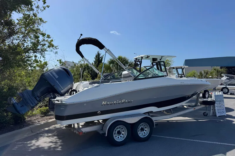 Slide: The Image of 2023 NauticStar 243 DC boat on trailer with Yamaha outboard motor, parked outdoors. - 3