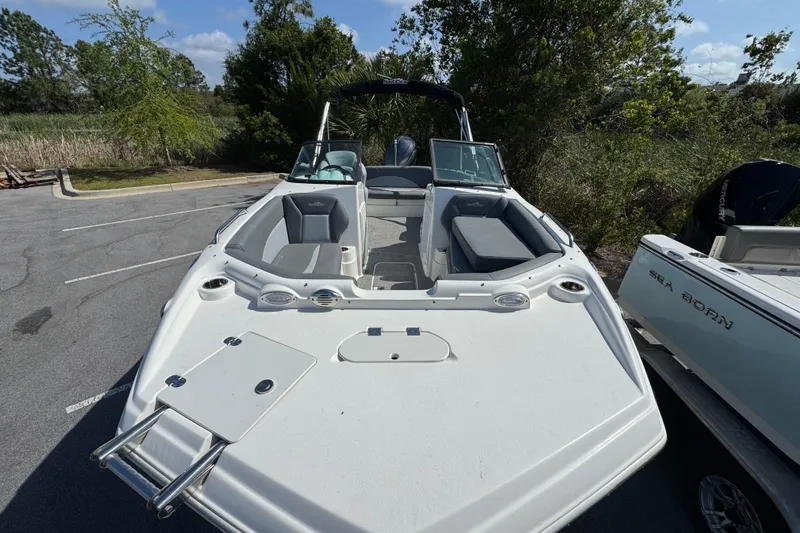 Slide: The Image of 2023 NauticStar 243 DC boat parked, showcasing sleek design and spacious seating. - 8