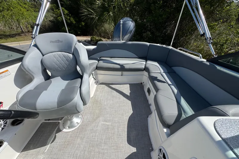 Slide: The Image of 2023 NauticStar 243 DC boat interior with gray seating and steering wheel. - 11