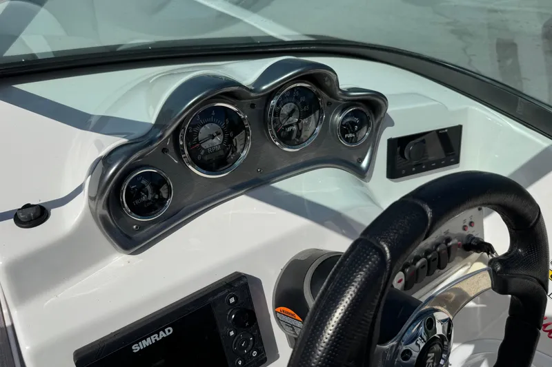 Slide: The Image of Dashboard of 2023 NauticStar 243 DC boat with gauges and steering wheel. - 14