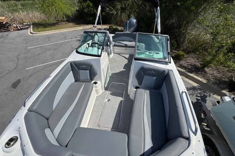 Slide: The Image of 2023 NauticStar 243 DC boat interior with gray seating and open deck layout. - 9