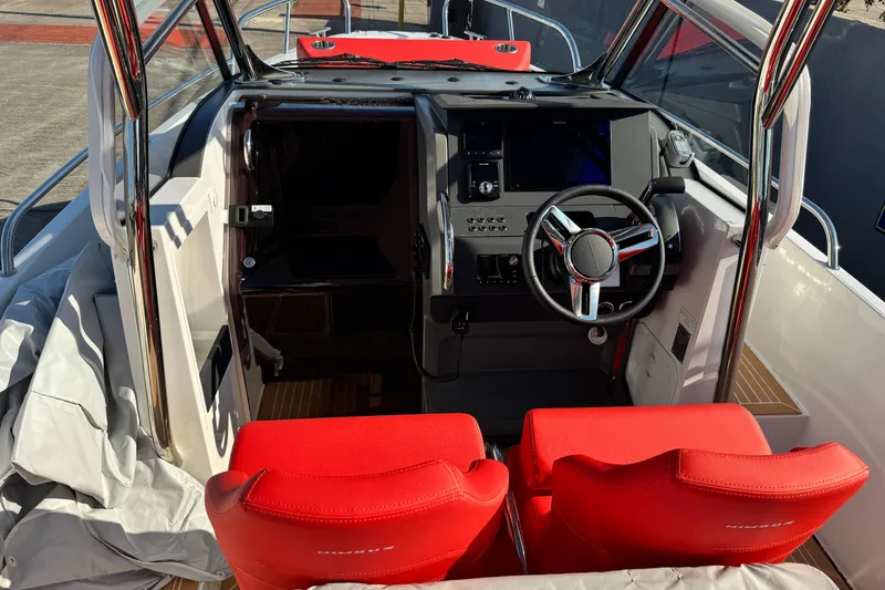 Slide: The Image of Interior of 2025 Nimbus Tender 8 boat with red seats and modern dashboard. - 22