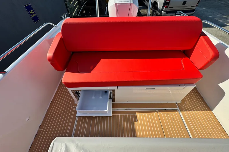 Slide: The Image of Red cushioned seating on 2025 Nimbus Tender 8 boat with storage drawer. - 29