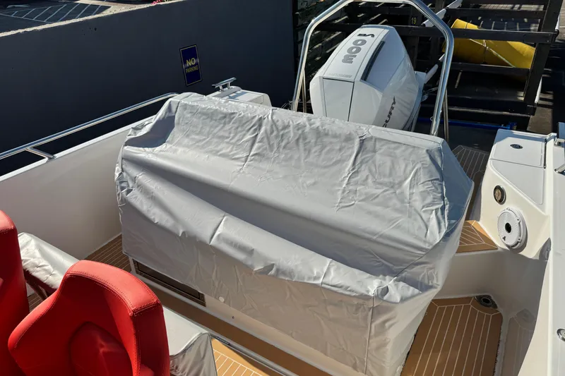 Slide: The Image of 2025 Nimbus Tender 8 boat with covered console and red seats. - 32