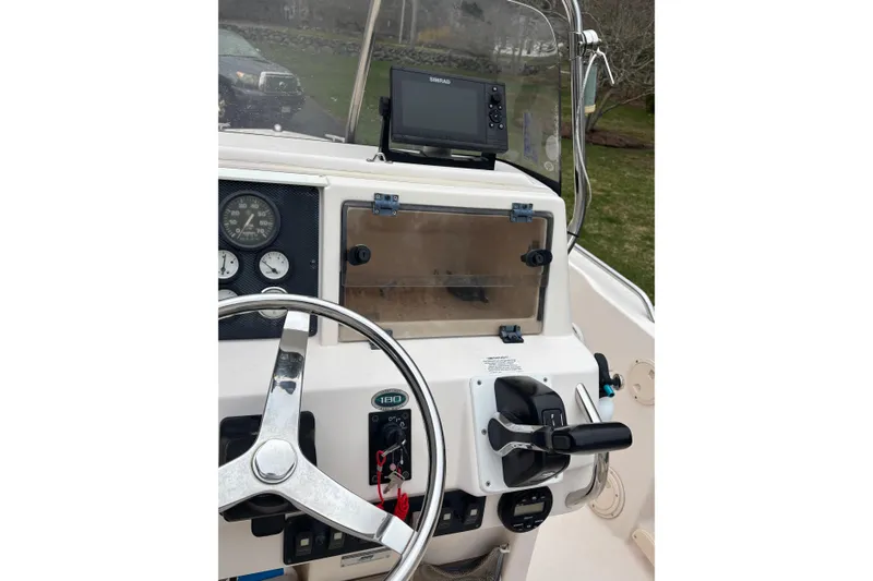 Slide: The Image of Console of a 2001 Grady-White Fisherman 180 boat with steering wheel and controls. - 12