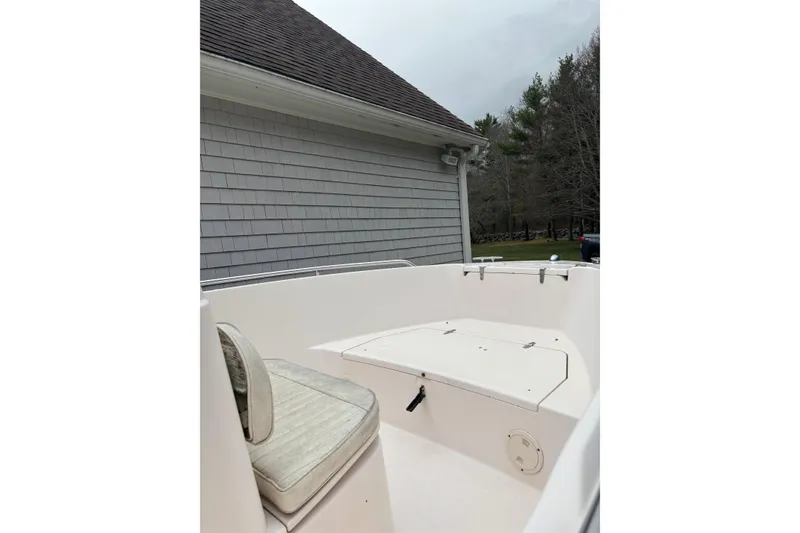 Slide: The Image of 2001 Grady-White Fisherman 180 boat interior, featuring seating and storage, near a house. - 9