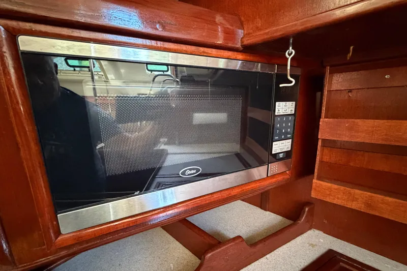 Slide: The Image of Microwave in 1992 Hunter Passage 42 yacht kitchen with wooden cabinetry. - 24