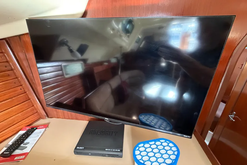 Slide: The Image of Flat-screen TV and DVD player inside a 1992 Hunter Passage 42 sailboat cabin. - 26