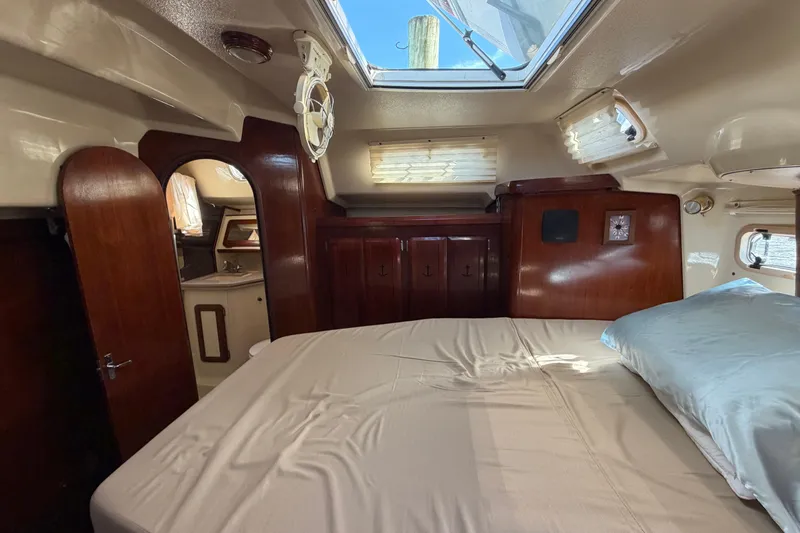 Slide: The Image of 1992 Hunter Passage 42 yacht interior with bed, wooden cabinets, and skylight. - 38