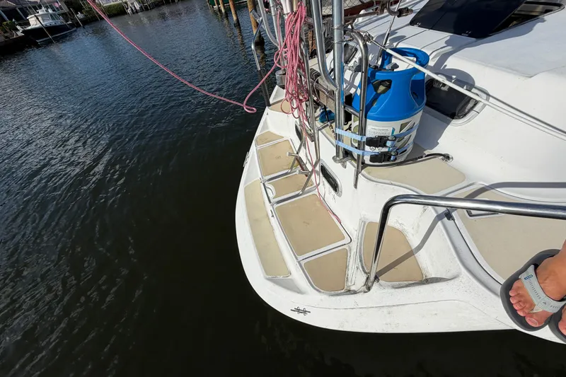 Slide: The Image of 1992 Hunter Passage 42 sailboat deck with propane tank and railing by the water. - 6