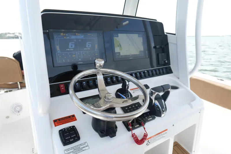 Slide: The Image of Control panel of 2021 Sea Hunt Ultra 305 SE boat with steering wheel and navigation screens. - 12