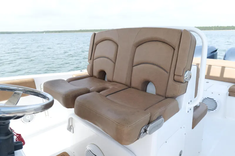 Slide: The Image of 2021 Sea Hunt Ultra 305 SE boat with brown cushioned seats and steering wheel. - 16