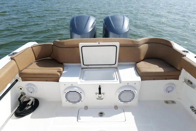 Slide: The Image of 2021 Sea Hunt Ultra 305 SE boat interior with seating and storage, on calm water. - 2