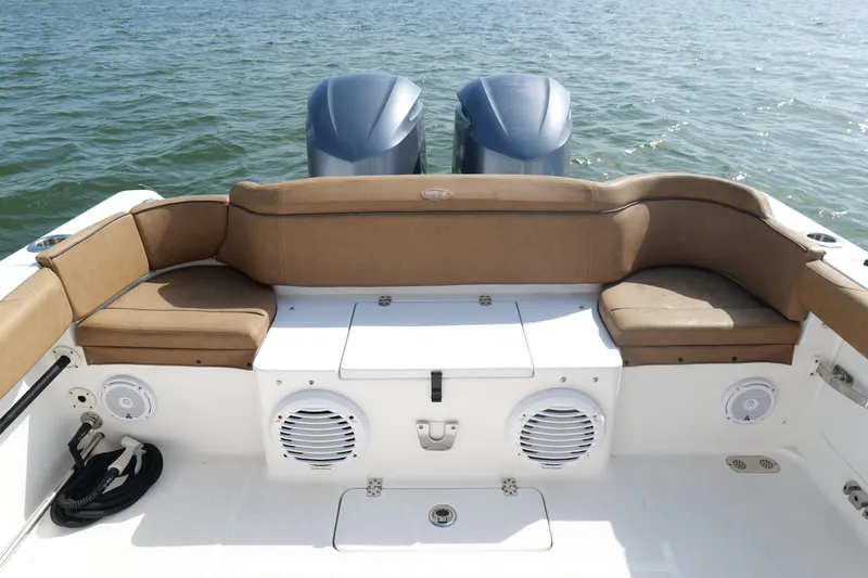 Slide: The Image of 2021 Sea Hunt Ultra 305 SE boat interior with cushioned seating and dual engines. - 20