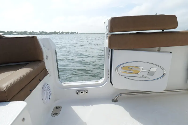 Slide: The Image of 2021 Sea Hunt Ultra 305 SE boat interior with brown seating and water view. - 22