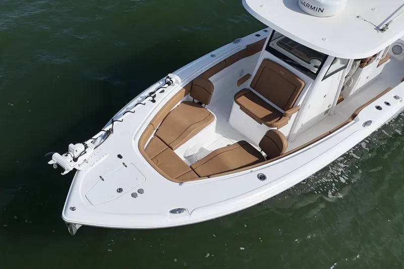Slide: The Image of 2021 Sea Hunt Ultra 305 SE boat with brown seating on water. - 24
